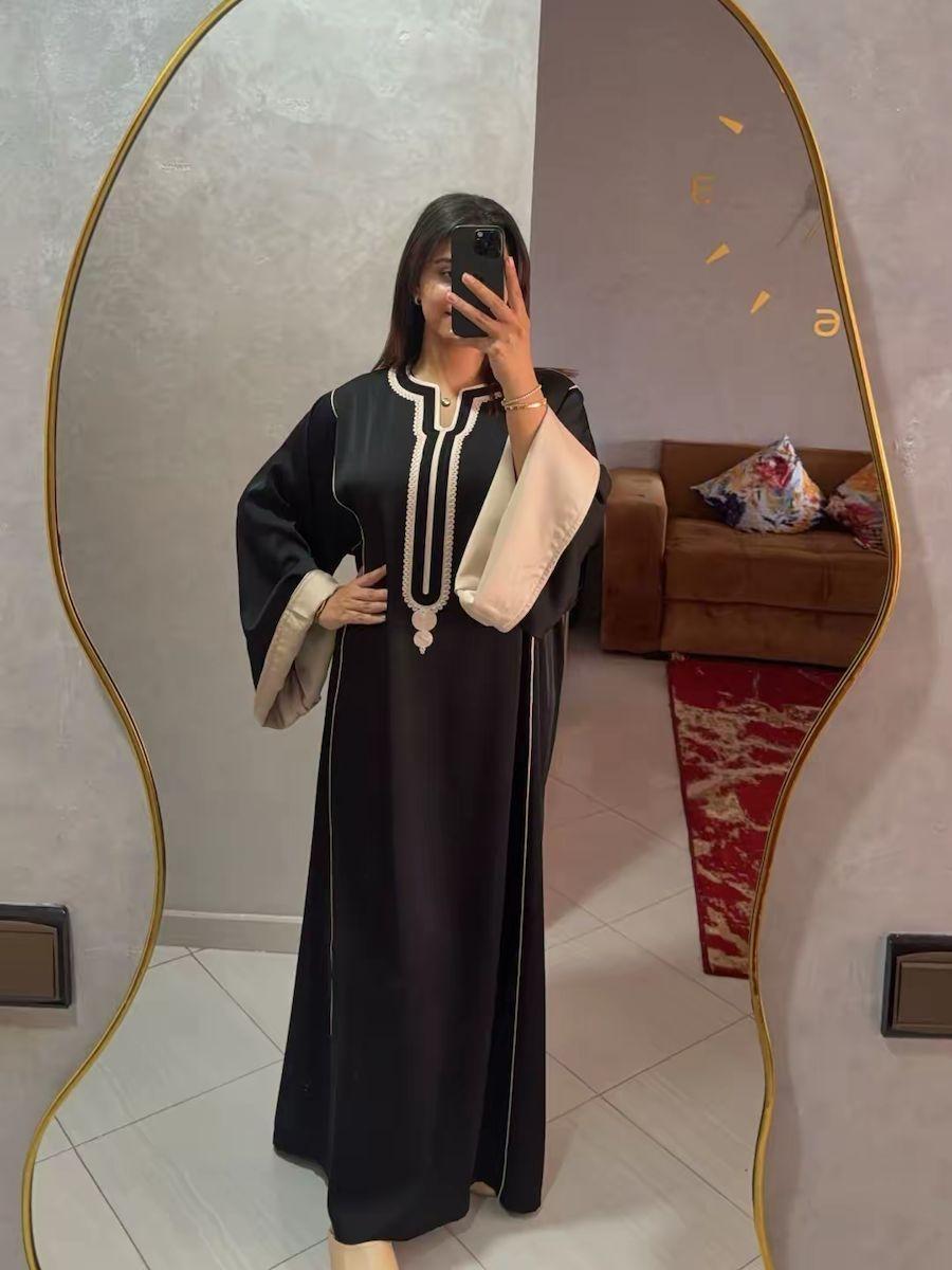 Caftan Sofia noir avec revers crème porté devant un miroir